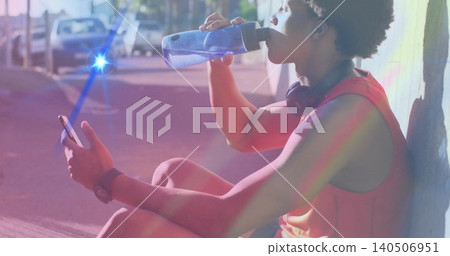 Drinking man in red tank top leaning on sunlit sidewalk with bottle phone headphones, copy space Drinking man in red tank top leaning on sunlit sidewalk with bottle phone headphones, copy space 140506951