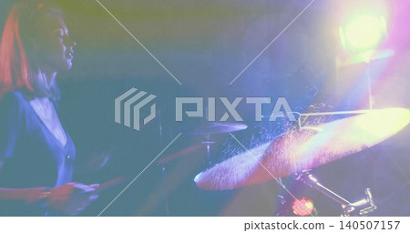 Striking drummer in dark v-neck hitting cymbal on spotlit stage, drumsticks and spray, copy space Striking drummer in dark v-neck hitting cymbal on spotlit stage, drumsticks and spray, copy space 140507157