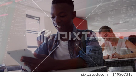 Smiling male student in denim shirt holding tablet at school, students writing, FileENCRYPTION Smiling male student in denim shirt holding tablet at school, students writing, FileENCRYPTION 140507313
