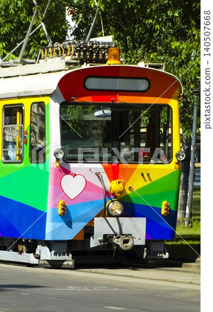 Rainbow colored tram with a heart symbol, highlighting a pride themed urban design celebrating diversity and inclusion. 140507668