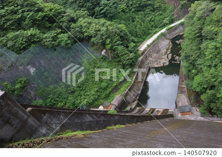 The valley below the Hyugami Dam and the concrete dam body The valley below the Hyugami Dam and the concrete dam body 140507920