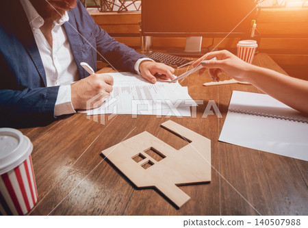 Man sign a home insurance policy on home loans. Estate agent with customer before contract signature. Man sign a home insurance policy on home loans. Estate agent with customer before contract signature. 140507988
