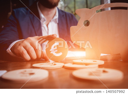 Businessman holds a coin near wooden piggy. Money box. Collecting money with earning bank. Businessman holds a coin near wooden piggy. Money box. Collecting money with earning bank. 140507992