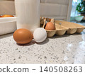 Assorted eggs, including brown and white varieties, resting on a speckled kitchen counter next to a carton and a bottle of milk, representing healthy dairy and poultry ingredients for cooking. 140508263