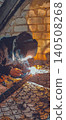 Tradesman wearing a protective mask is welding a metal fence panel, generating bright sparks and smoke in a workshop, symbolizing hard work, industry, and construction. 140508268