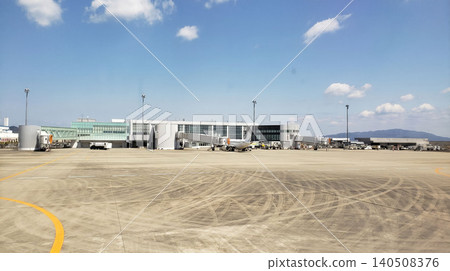 A parking area and passenger plane at a regional airport on a clear day. A parking area and passenger plane at a regional airport on a clear day. 140508376