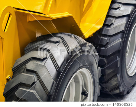 Heavy machine tire and wheel close-up on a construction site during daytime work Heavy machine tire and wheel close-up on a construction site during daytime work 140508525