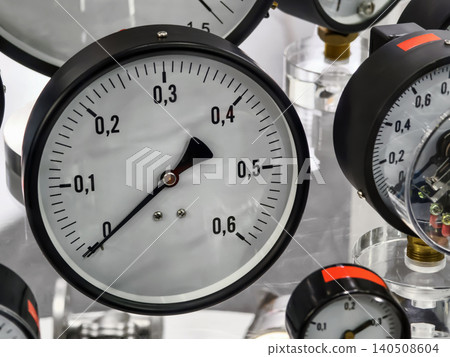 Pressure gauges are displayed in a row at a workshop showing different measurements and readings during the day Pressure gauges are displayed in a row at a workshop showing different measurements and readings during the day 140508604
