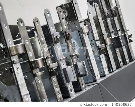 Different types of metal locks are arranged in a row in an industrial setting showing their design and construction details 140508622