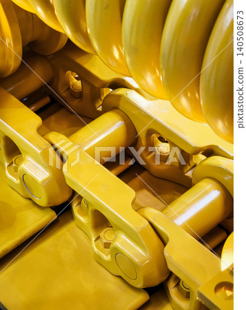 Heavy machinery parts show detail of yellow equipment with focus on gears and links in industrial setting Heavy machinery parts show detail of yellow equipment with focus on gears and links in industrial setting 140508673