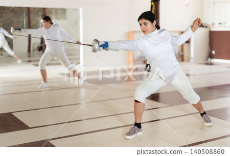 Latina woman in white overalls in fencing club Latina woman in white overalls in fencing club 140508860