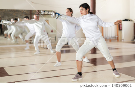 Latina woman in white overalls in fencing club Latina woman in white overalls in fencing club 140509001