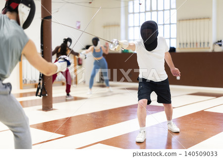 Group of fencers trains in duels and works out blows on the pillows in gym 140509033