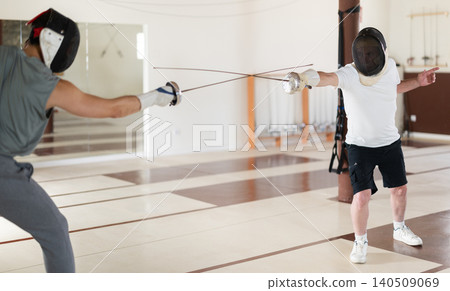 men in protective equipment conduct a training fencing match men in protective equipment conduct a training fencing match 140509069