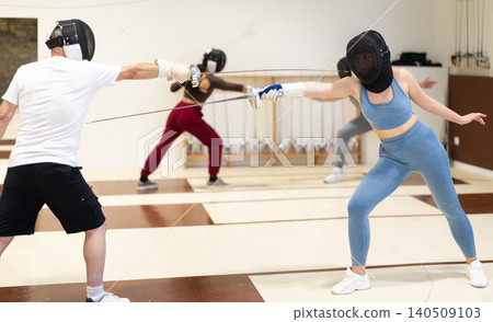 Two people participate in sparring in a fencing club Two people participate in sparring in a fencing club 140509103