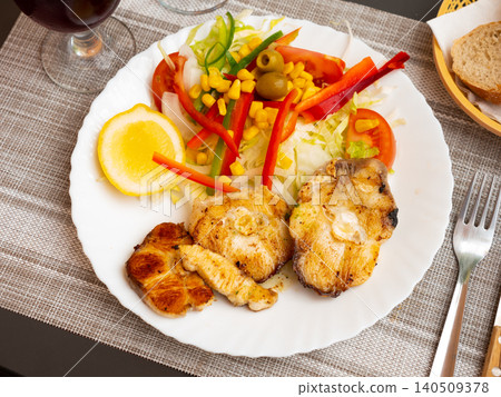 Oven baked hake with vegetable garnish Oven baked hake with vegetable garnish 140509378