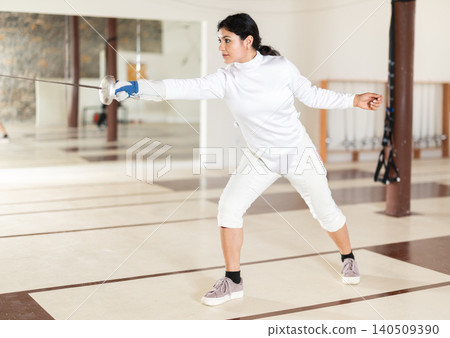 Latina woman in white overalls in fencing club Latina woman in white overalls in fencing club 140509390