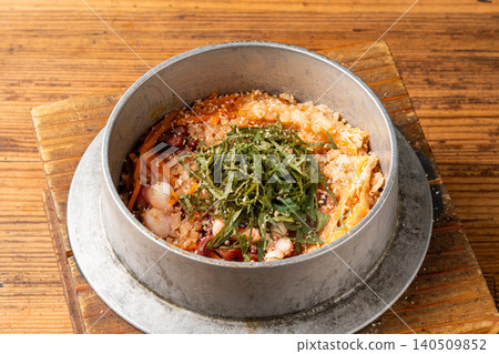 Octopus rice cooked in a pot, highlighting the texture of the octopus and the aroma of perilla leaves. Octopus rice cooked in a pot, highlighting the texture of the octopus and the aroma of perilla leaves. 140509852