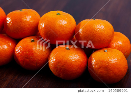 Ripe clementines on wooden table in kitchen Ripe clementines on wooden table in kitchen 140509991