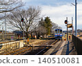 A winter railway scene: A train on the Kanto Railway Joso Line arriving at a local station. 140510081
