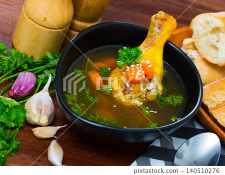 Delicious soup with chicken, bacon, leek and vegetables served in bowl Delicious soup with chicken, bacon, leek and vegetables served in bowl 140510276