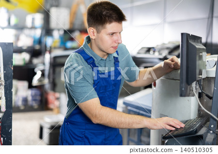Man worker operating computerised machine to mix paint in paint shop Man worker operating computerised machine to mix paint in paint shop 140510305