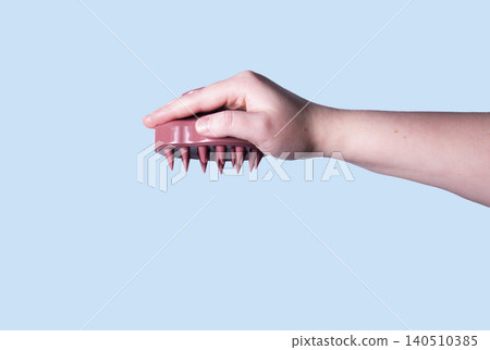 Pink silicone scalp massager in woman hand mockup. Hair brushing and massage. Isolated image for design Pink silicone scalp massager in woman hand mockup. Hair brushing and massage. Isolated image for design 140510385