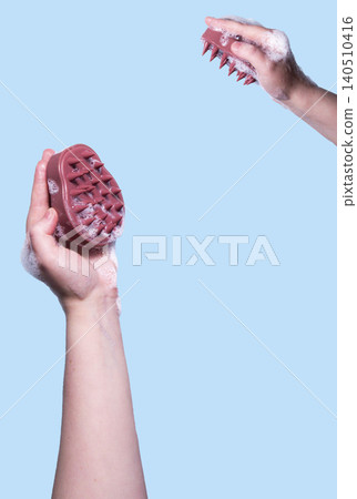 Scalp massage with exfoliating brush on blue background. Illustration of washing routine. Concept of scalp care, trichology, natural cosmetics, and home wellness therapy. Vertical image Scalp massage with exfoliating brush on blue background. Illustration of washing routine. Concept of scalp care, trichology, natural cosmetics, and home wellness therapy. Vertical image 140510416