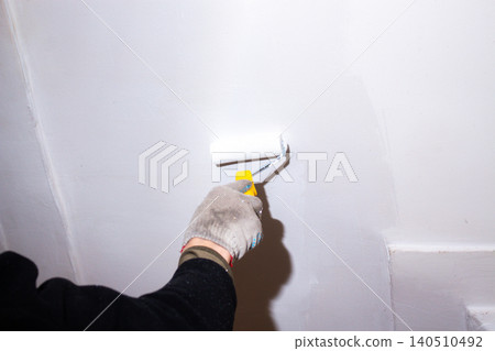 Close up of roller soaking up white paint. DIY approach to home care. Pleasant changes start small. Family budget control through self-repair Close up of roller soaking up white paint. DIY approach to home care. Pleasant changes start small. Family budget control through self-repair 140510492