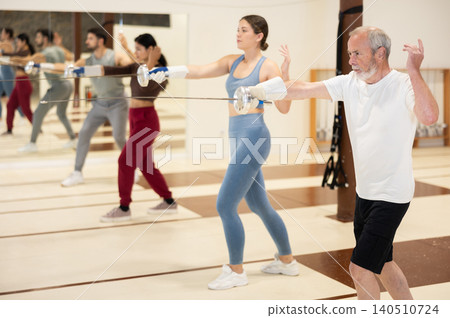 Group of fencers practicing sword movements in gym Group of fencers practicing sword movements in gym 140510724