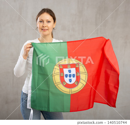 Attractive female football fan holding Portugal flag Attractive female football fan holding Portugal flag 140510744