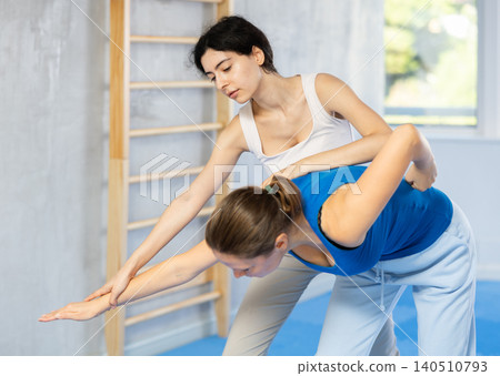 Woman is practicing self defence moves in pair with her female trainer at gym Woman is practicing self defence moves in pair with her female trainer at gym 140510793