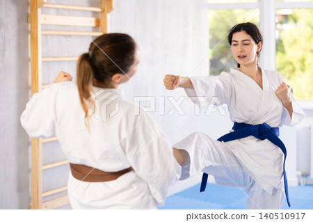 Women exercising karate movements during group training Women exercising karate movements during group training 140510917