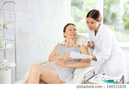 Woman doctor give patient medical documents for review before carrying out cosmetic procedure Woman doctor give patient medical documents for review before carrying out cosmetic procedure 140511039