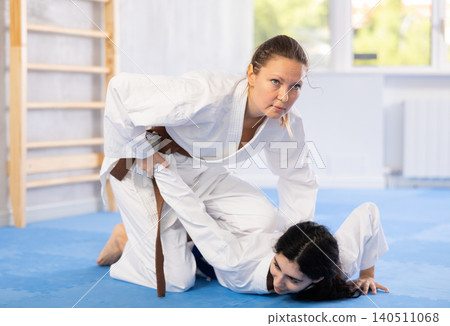 Two women training judo techniques in studio Two women training judo techniques in studio 140511068