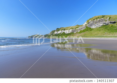 The stunning scenery of the singing sand beach and towering cliffs at Itanki Beach in Muroran City, Hokkaido. 140511307