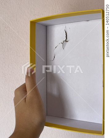 Damaged cardboard puzzle box held by hand showing torn packaging Damaged cardboard puzzle box held by hand showing torn packaging 140512750