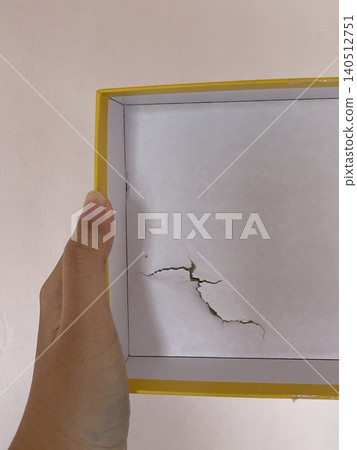 Damaged cardboard puzzle box held by hand showing torn packaging Damaged cardboard puzzle box held by hand showing torn packaging 140512751