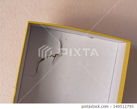 Damaged cardboard puzzle box showing shipping impact and packaging dents 140512793