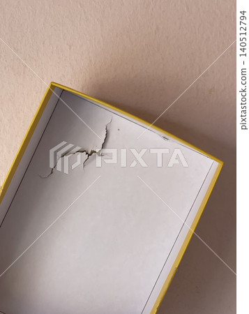 Damaged cardboard puzzle box showing shipping impact and packaging dents Damaged cardboard puzzle box showing shipping impact and packaging dents 140512794