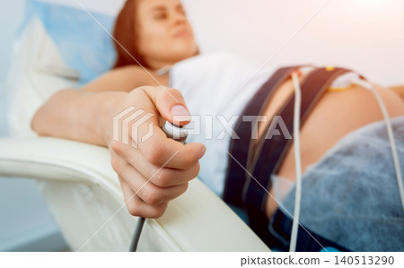 Pregnant woman with electrocardiograph check up for her baby. Fetal heart monitoring Pregnant woman with electrocardiograph check up for her baby. Fetal heart monitoring 140513290