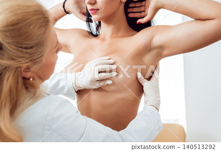Doctor get examining breast of young woman. Consultation with gynecologist. 140513292