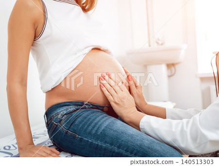 A gynecologist examines a pregnant woman. Patient at doctor office. Pregnant woman at hospital. 140513303