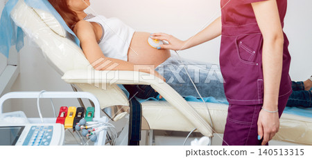 Pregnant woman with electrocardiograph check up for her baby. Fetal heart monitoring 140513315