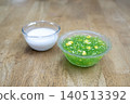 Traditional Thai dessert sago with corn and coconut milk. Saku Kao Pod in glass bowls on wooden table. Asian sweet snack with green tapioca pearls and yellow corn kernels. Close up food photo. 140513392