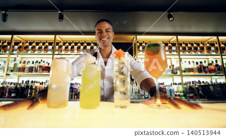 Bartender smiling proudly presenting variety of cocktails at bar 140513944