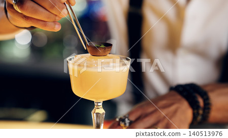 Bartender preparing a gourmet cocktail with unique garnish Bartender preparing a gourmet cocktail with unique garnish 140513976