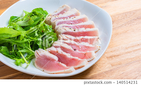Rare-cooked tuna steak served with baby greens. Rare-cooked tuna steak served with baby greens. 140514231