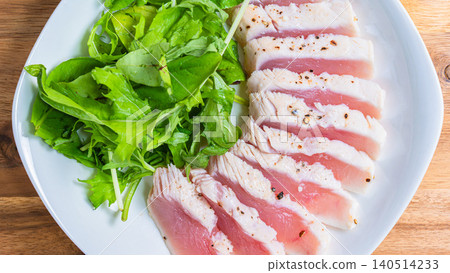 Rare-cooked tuna steak served with baby greens. Rare-cooked tuna steak served with baby greens. 140514233