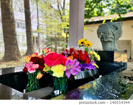 Flower arrangements in a water basin at Ooyachi Shrine, Sapporo, Hokkaido. 140514344